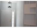 Bright entryway with a decorative light fixture, white door with glass panes, and built-in shelving at 6500 Abercrombie Ct, Orlando, FL 32835