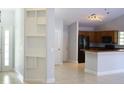Open living space with tile floors, built-in shelving, and a view of the kitchen area at 6500 Abercrombie Ct, Orlando, FL 32835