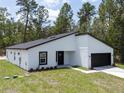 Stylish single-story home with a modern design, a black door, and a two-car garage at 6516 Sw 149 Th Lane Rd, Ocala, FL 34473