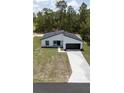 New construction home with dark accents, a two-car garage, and a long driveway at 6516 Sw 149 Th Lane Rd, Ocala, FL 34473
