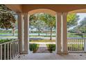 Covered front porch with stately columns, showcasing the beautiful neighborhood and tranquil lake at 7184 Maleberry Run, Winter Garden, FL 34787