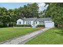 Charming single-story home with a long driveway and mature trees provides inviting curb appeal at 826 Garden Plz, Orlando, FL 32803
