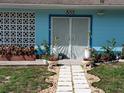 Close up of front entrance featuring a security door, planter box, and front lawn at 833 Channing Rd, Lakeland, FL 33805