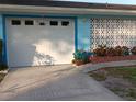 View of the garage door with brick planter and flowers in front at 833 Channing Rd, Lakeland, FL 33805