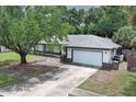 Charming single-story home with a well-maintained lawn and long driveway at 9551 Lake Douglas Pl, Orlando, FL 32817