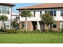 Charming townhome exterior featuring manicured landscaping, stone accents, and a well-maintained lawn at 10072 Sunnifa Aly, Orlando, FL 32832
