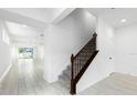 Open-concept hallway with tile floors, a carpeted staircase with dark wood banister and wrought iron spindles at 12216 Encore At Ovation Way, Winter Garden, FL 34787