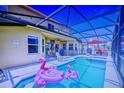 Screened-in pool area with an outdoor dining set and lounge chairs, and inflatable pink flamingos at 148 Miro Dr, Davenport, FL 33837