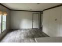 Bright living room featuring wood-look laminate flooring, neutral walls, and plenty of natural light at 15400 Ne 236Th Pl, Fort Mc Coy, FL 32134