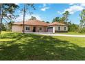 Charming single-story home with a well-manicured lawn and a long driveway leading to an attached garage at 19606 Reynolds Pkwy, Orlando, FL 32833