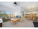 Bright living room with neutral carpet, large window, and open concept layout to kitchen at 20130 Sunset Landing Ave, Groveland, FL 34736