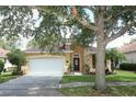 Well-maintained one-story home with stucco exterior, a two-car garage, and mature trees shading the front yard at 203 Brookgreen Way, Deland, FL 32724