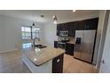 Modern kitchen with stainless steel appliances, granite countertops, and dark wood cabinets at 2355 Seven Oaks Dr, St Cloud, FL 34772