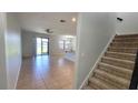 Open-concept living room with tile floors, ceiling fan, and sliding glass doors to the screened porch at 2355 Seven Oaks Dr, St Cloud, FL 34772
