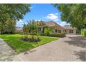 A paved driveway leads to a lovely home with lush landscaping and mature trees at 25554 Hawks Run Ln, Sorrento, FL 32776