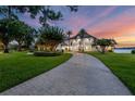 A beautiful home with a curving driveway, mature trees, and a peaceful view of the lake at 2937 Butler Bay N Dr, Windermere, FL 34786