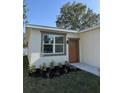 Close up of a house with neutral colored trim around a large window and matching colored door at 320 W Necho Ave, Lake Alfred, FL 33850