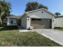 A charming home featuring new landscaping, neutral paint, a brown garage door and a matching front door at 320 W Necho Ave, Lake Alfred, FL 33850
