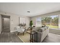Bright living room featuring neutral paint, hardwood floors, a large window, and modern furnishings at 338 Henry Butts Dr, Daytona Beach, FL 32114