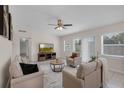 Bright living room featuring neutral furniture, a ceiling fan, and sliding glass doors to the pool at 3430 Arbutus Ln, Winter Park, FL 32792