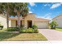 Charming single-story home with a tile roof, lush landscaping, and a brick driveway on a sunny day at 3906 Carrick Bend Dr, Kissimmee, FL 34746