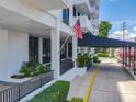 Covered entrance to the building with landscaping, planters, and US flag at 400 E Colonial Dr # 1501, Orlando, FL 32803