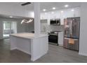 Well-lit kitchen with stainless steel appliances, white cabinets, island and modern lighting at 438 Romano Ave, Orlando, FL 32807