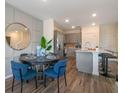 Open-concept dining area with a round table, leading into a modern kitchen with gray cabinetry at 5641 Brosnan Rd, St Cloud, FL 34771