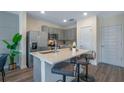 Well-equipped kitchen featuring a spacious island with seating, stainless steel appliances, and gray cabinets at 5641 Brosnan Rd, St Cloud, FL 34771