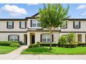 Inviting townhome exterior features well-manicured lawn and a charming tree in the front yard at 600 Northern Way # 607, Winter Springs, FL 32708