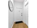 Clean, bright entryway with wood floors, a stylish mirror, and a secure white door at 814 Calabria Ave, Davenport, FL 33897