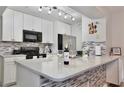 Bright kitchen with stainless steel appliances, white cabinets, tile backsplash, and countertop at 8709 Knightsbridge Ct # B, Kissimmee, FL 34747