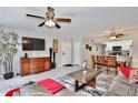 Inviting living room features a decorative fireplace, grey sofa, dining table and ceiling fan at 8709 Knightsbridge Ct # B, Kissimmee, FL 34747