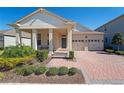 Beautiful front exterior featuring a brick driveway, a covered front porch, and an attached two-car garage at 8935 Sonoma Coast Dr, Winter Garden, FL 34787