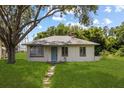 Charming single-story home with a well-maintained lawn and mature trees at 105 N Florida Ave, Howey In The Hills, FL 34737