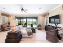 Bright living room with neutral tones, tile flooring, and sliding glass doors offering a view of the pool at 1156 Castle Pines Ct, Reunion, FL 34747