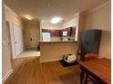An open concept kitchen with a breakfast bar and a living room featuring hardwood floors at 1370 Tuscan Ter # 2202, Davenport, FL 33896