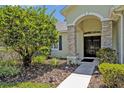 Inviting front entrance with stone accents, arched doorway, and meticulous landscaping at 14128 Bramble Bush Ct, Orlando, FL 32832