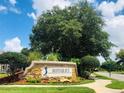 Entrance to Mayfair Run featuring stone sign and lush landscaping at 14700 Chadbury Ct, Orlando, FL 32828