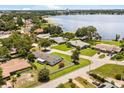Aerial view of a neighborhood featuring a lake nearby, green lawns, and mature trees on large lots at 1505 N Lake Mirror Nw Dr, Winter Haven, FL 33881