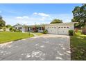 Exterior shot showing a concrete driveway leading to a charming single story home and attached two car garage at 1505 N Lake Mirror Nw Dr, Winter Haven, FL 33881
