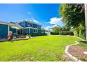 Expansive backyard featuring lush green lawn, landscaping, and an outdoor dining area at 1609 E Kaley Ave, Orlando, FL 32806