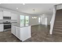 Bright kitchen features white cabinets, stainless steel appliances and open floorplan at 16242 Outlook Shore Aly, Winter Garden, FL 34787