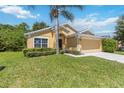 Inviting single-story home features a two-car garage, mature landscaping, and a well-maintained lawn at 165 Scrub Jay Way, Davenport, FL 33896