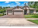 Attractive single-story home featuring a three-car garage and meticulously maintained landscaping at 1692 Blue Grass Blvd, Deland, FL 32724