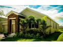 Beautiful one-story home featuring lush landscaping with vibrant green tropical trees at 1889 Blissful Dr, Kissimmee, FL 34744