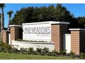 Elegant community sign reading 'Pine Meadows Reserve' with manicured landscaping, making a welcoming entrance at 2416 Cabinwood Range Way, Eustis, FL 32726