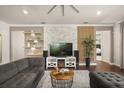 Inviting living room with decorative shelving, brick accent wall, hardwood floors, and plush seating at 2896 Matera Dr, St Cloud, FL 34771