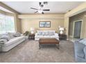 Comfortable living room with neutral carpeting, ceiling fan, and large window for natural light at 3100 Pine Needle Trl, Kissimmee, FL 34746