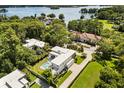 Stunning aerial view of estate home with pool, lush landscaping, and beautiful lake in the background at 350 Northwind Rd, Maitland, FL 32751
